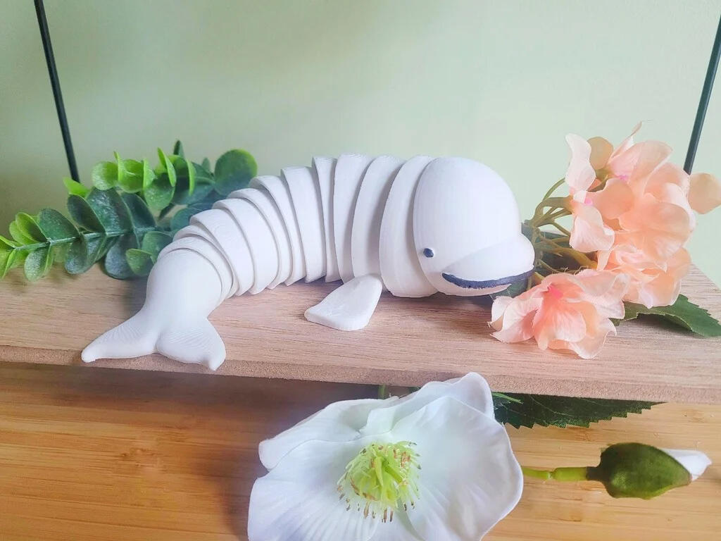 Untitled A 3D printed, articulated fidget toy modeled to look like a beluga. The beluga's body is made of multiple interlocking segments that allow him to bend and flop around.