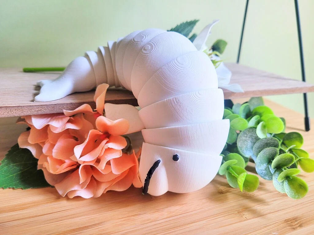 Untitled A 3D printed, articulated fidget toy modeled to look like a beluga. The beluga's body is made of multiple interlocking segments that allow him to bend and flop around.