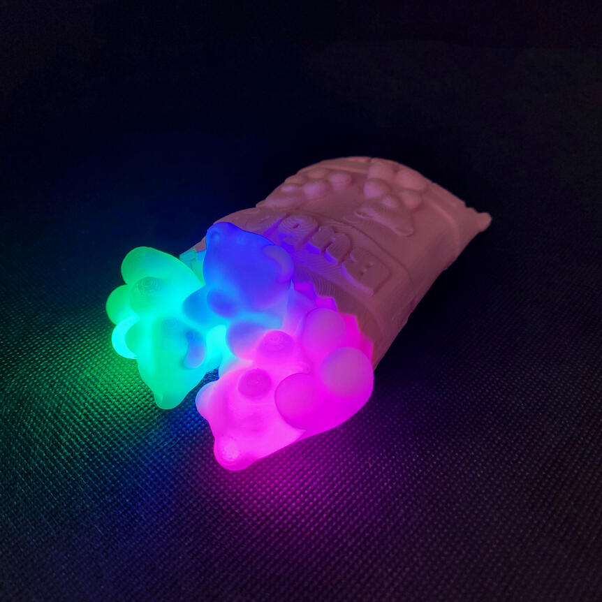 Untitled Small 3D printed light made to look like a spilled bag of gummy bears. Each gummy bear is illuminated from the inside with a different color light. There are three gummy bears: green, blue, magenta.